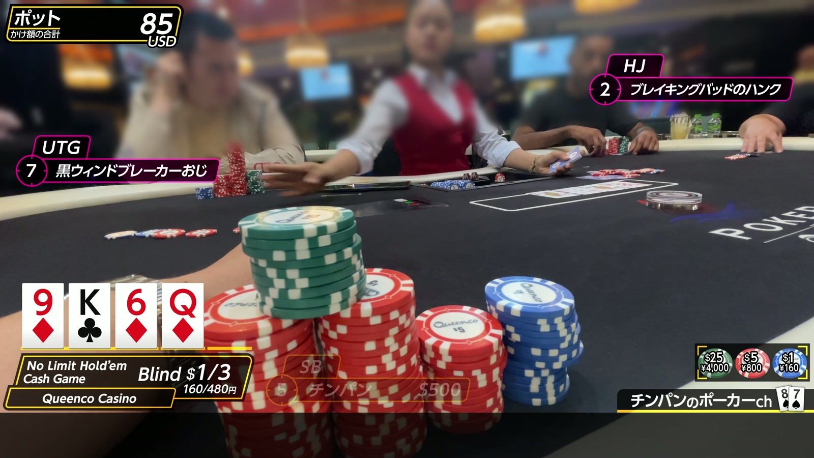 Queenco Casino でのプレイ中。ディーラー、チップ、テーブルに並んだカード